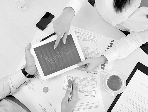 Team reviewing clinical development data and charts on a tablet during a consulting session