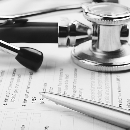 Stethoscope and pen on clinical research documents